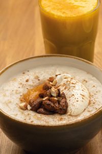 Breakfast at Urban Angel cafe, Edinburgh. Porridge with yoghurt with compote, nuts and cacao, with yohurt. In the background a freshly made smoothie with tumeric.